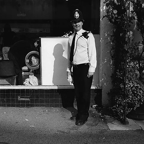 Policeman standing on street.