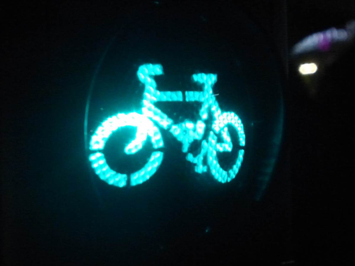 Green traffic signal light for cyclists on London street.